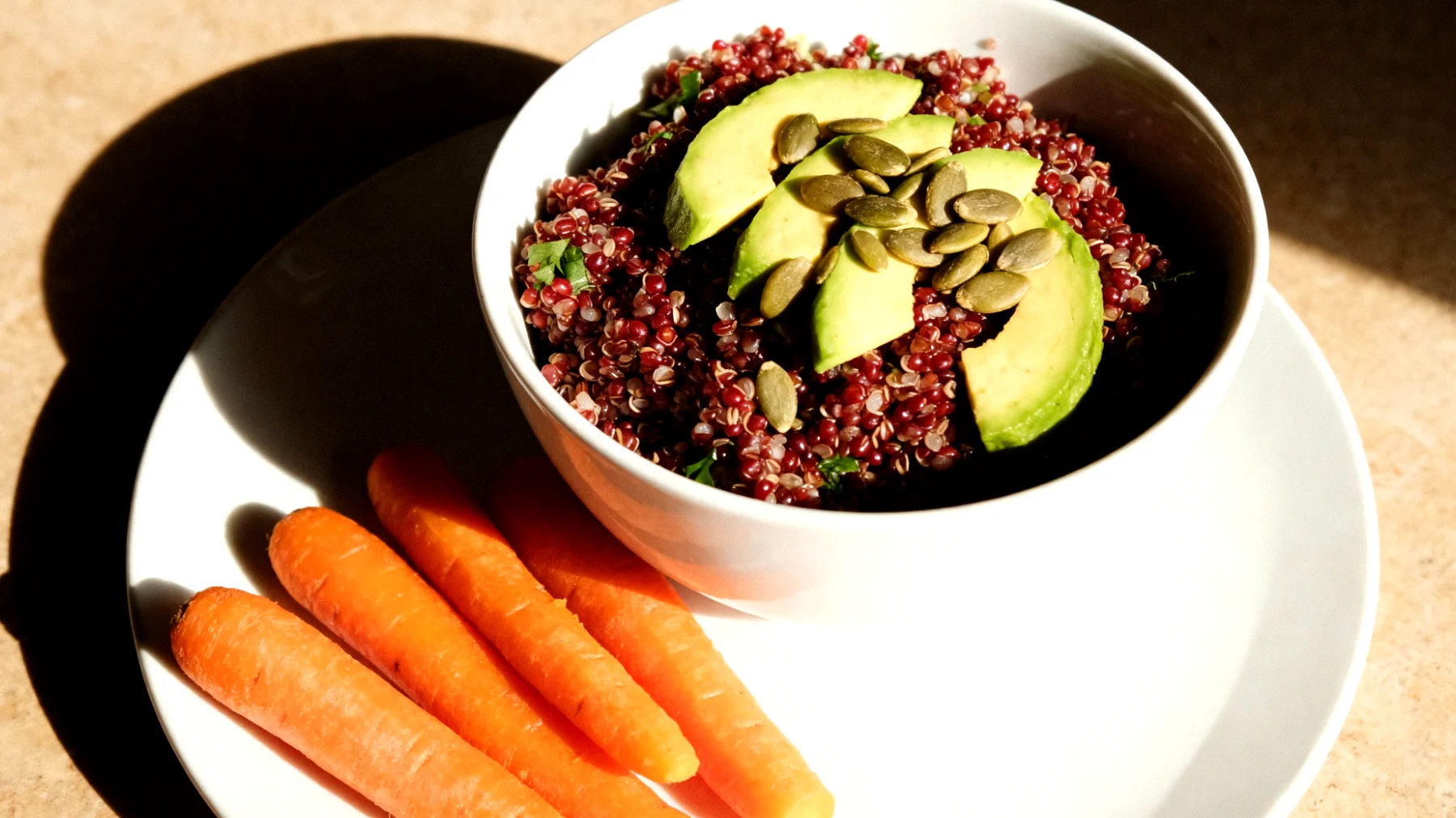Insalata di quinoa rossa con avocado, semi di zucca e carote al vapore"