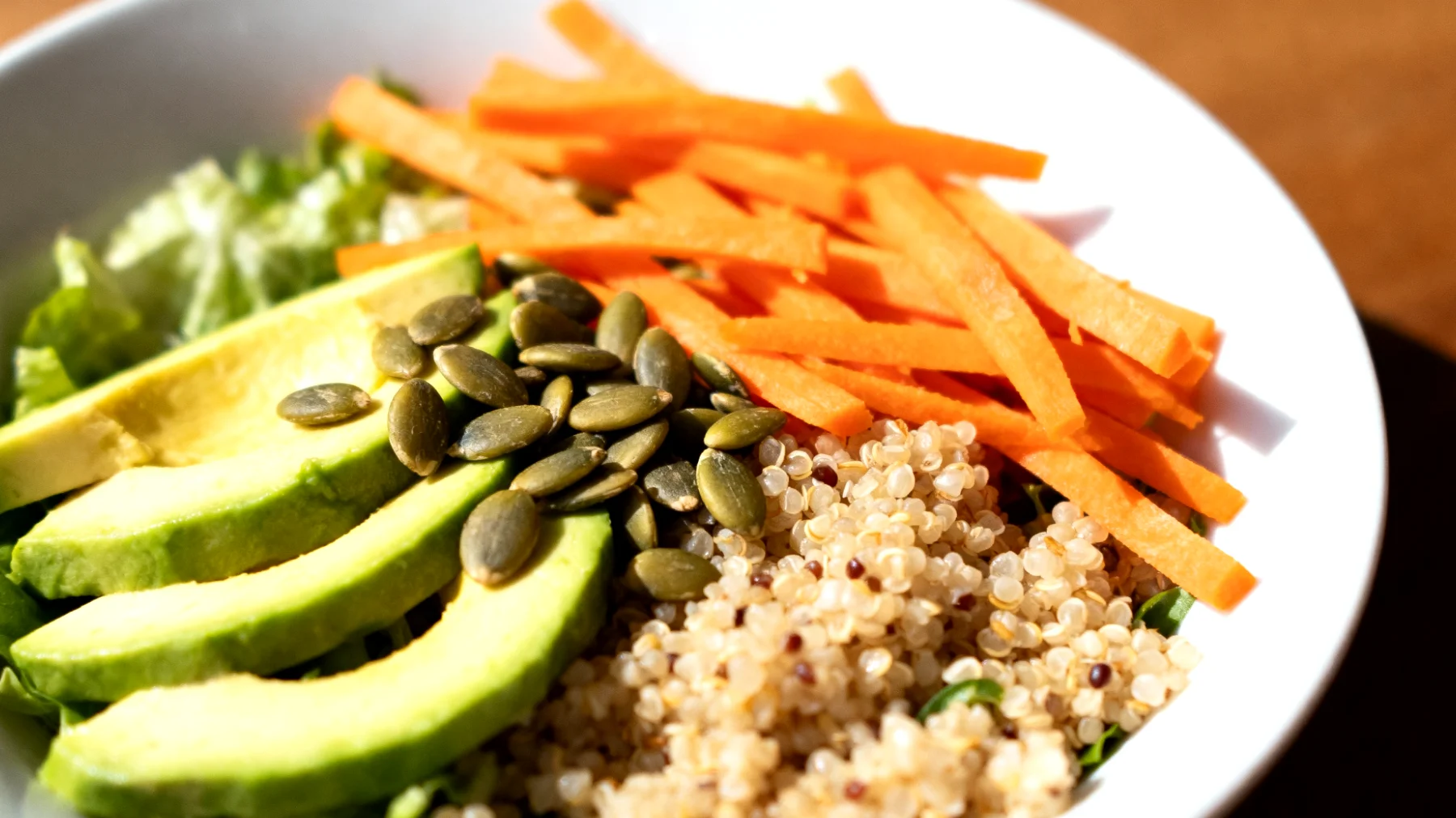 Insalata di quinoa con avocado, semi di zucca e carote crude"