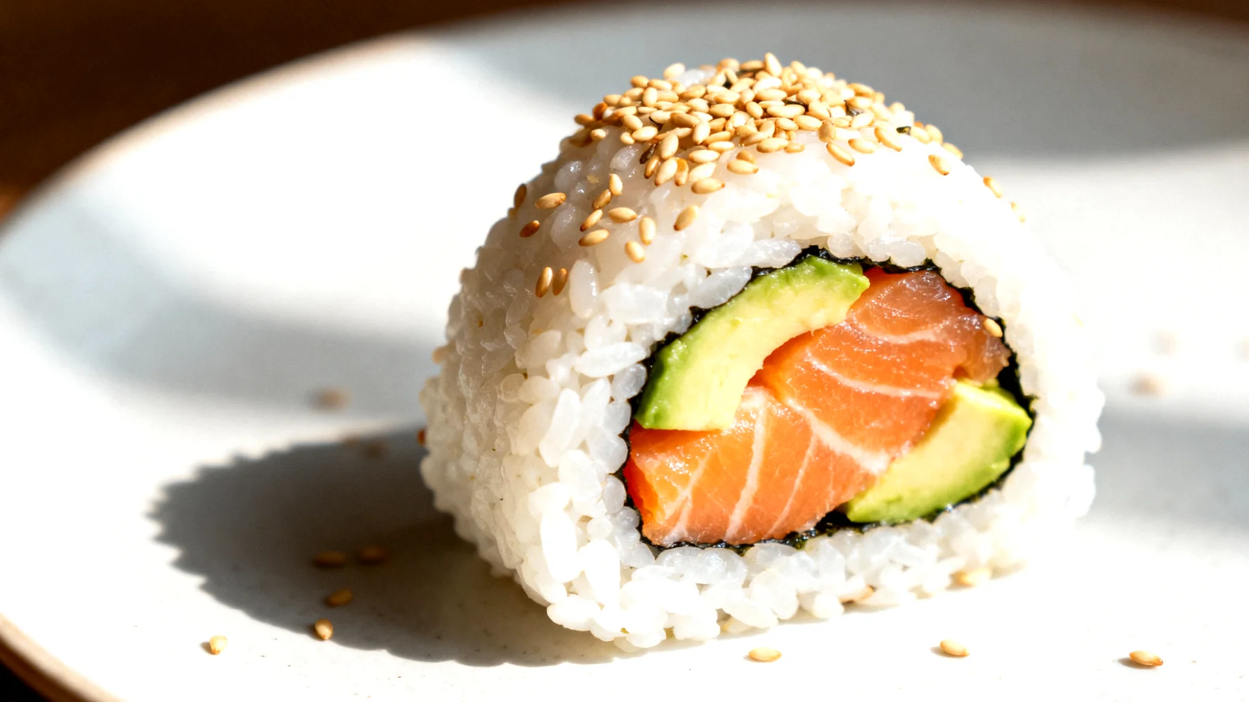 Onigiri con salmone, avocado e semi di sesamo"